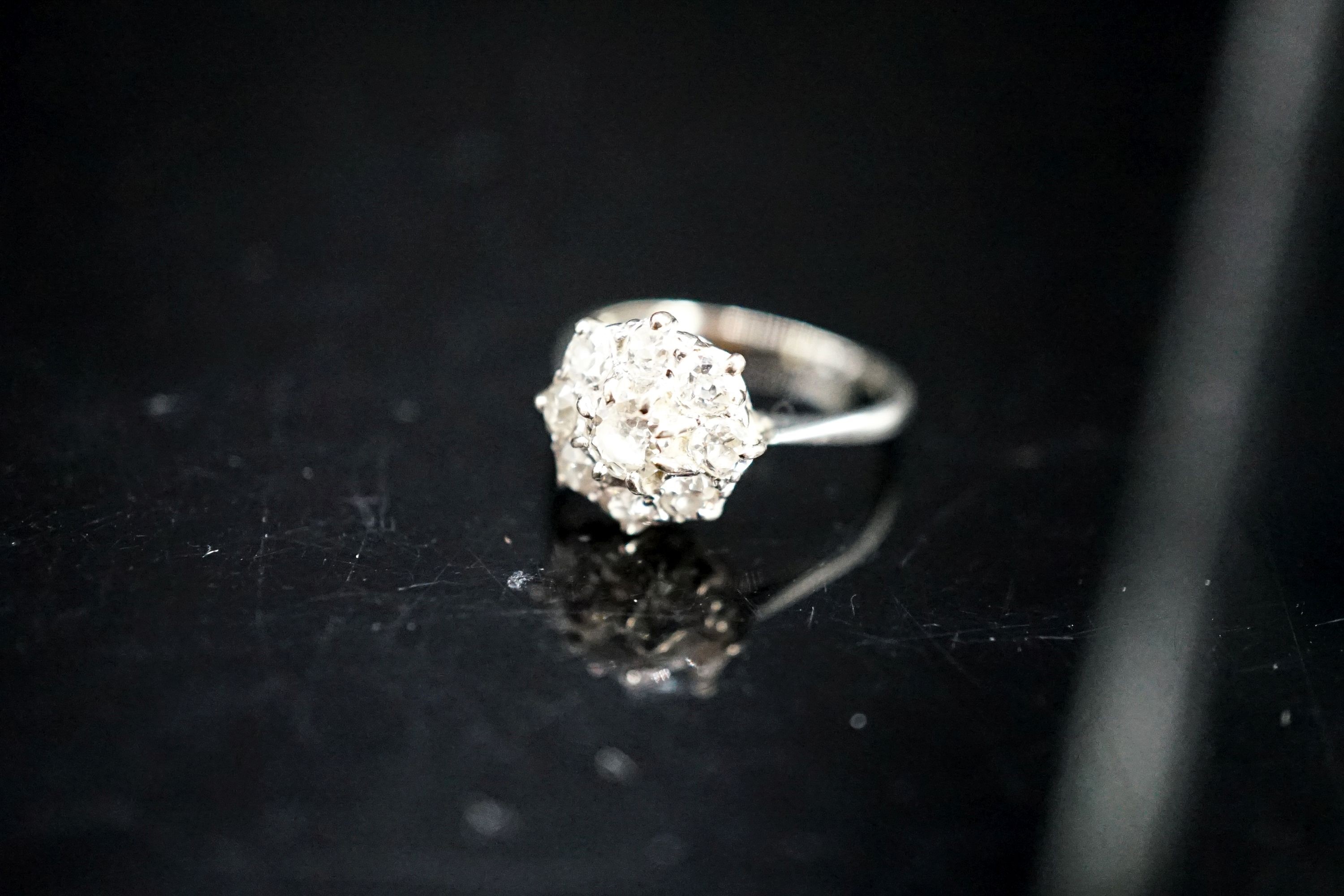 A white metal and diamond cluster ring, size J, gross 2 grams.